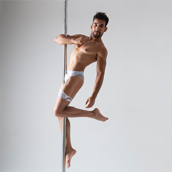 Rafael Trajano, pole and aerial teacher at London Dance Academy, posing on pole